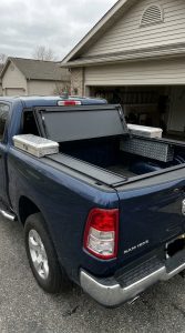 Ram 1500 truck bed fitted with a folding tonneau cover and side toolbox